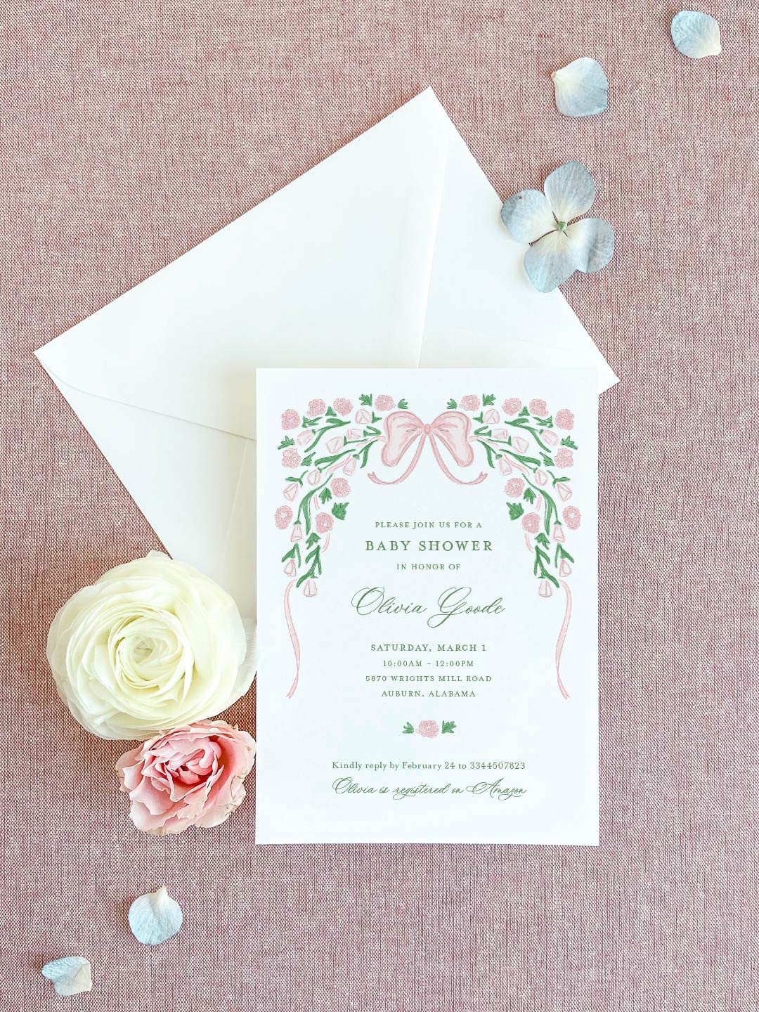 Baby shower invitation with pink floral ribbon design and personalized green script on textured pink background