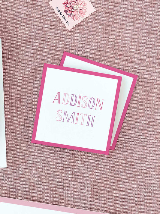 Square pink-bordered calling cards with elegant pink outlined letters on white, personalized for event or wedding stationery.