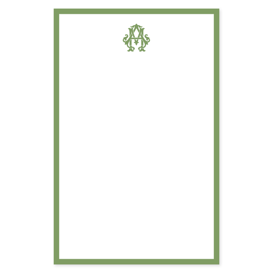 Elegant notepad page featuring a classic green border and a decorative monogram design at the top, ideal for personalized stationery.