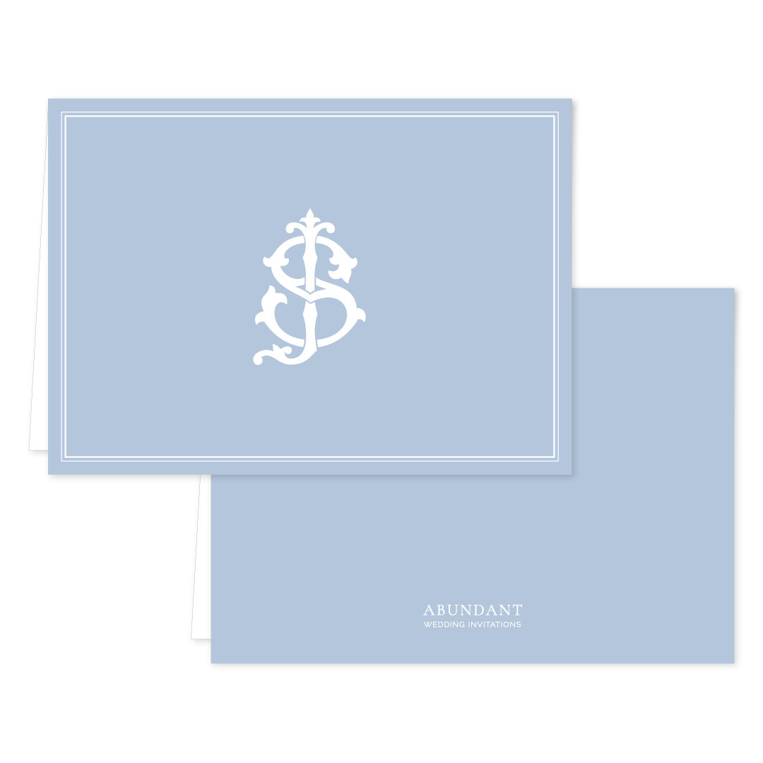 Folded notecard in pale blue with a classic white monogram design on the front and simple branding on the back, perfect for personalized stationery.