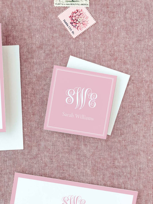Square personalized calling card in soft blush pink with elegant white monogram and name on textured fabric background