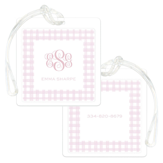 Square bag tags featuring a soft pink gingham border with personalized monogram and name on one side and contact number on the other, attached to clear plastic loops.