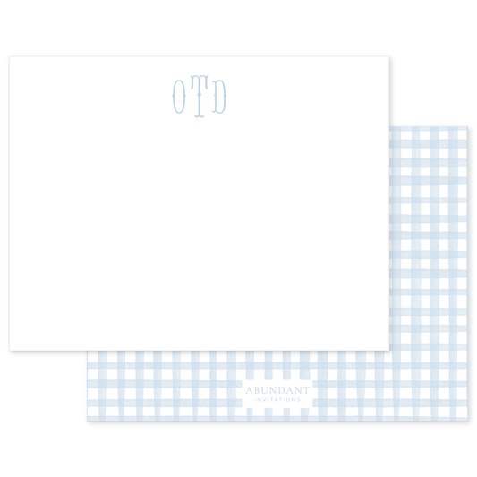 Elegant flat notecard featuring a light blue gingham pattern with a personalized monogram and subtle branding for a classic, timeless feel.