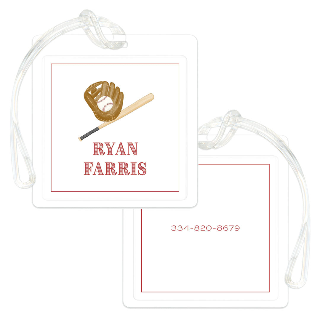 Square bag tag with baseball glove and bat illustration, personalized with a name on one side and a phone number on the other, featuring a clear strap for attachment.