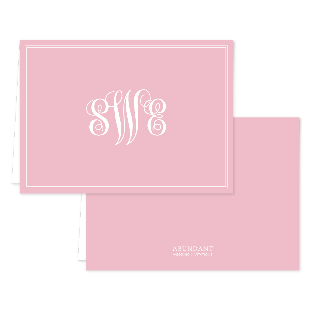 Elegant folded notecard in soft blush pink featuring a white monogram and classic border design, perfect for personalized stationery.