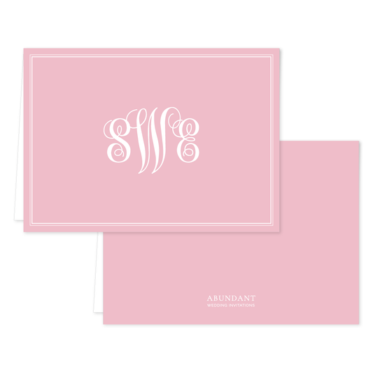 Elegant folded notecard in soft blush pink featuring a white monogram and classic border design, perfect for personalized stationery.