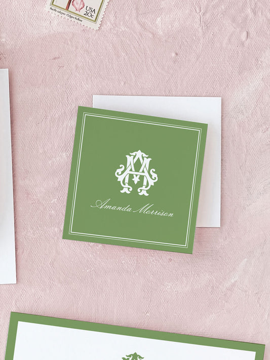 Square personalized calling card in classic green featuring elegant white monogram and cursive name on textured pink background