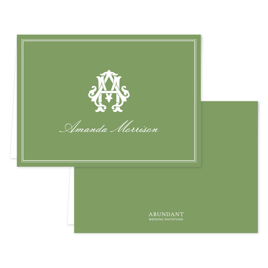 Folded green notecard with elegant white monogram and cursive name on front, simple matching back featuring subtle branding.