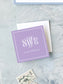 Square lavender calling card with elegant white monogram and personalized name on textured background