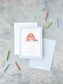 Blue checkered birthday invitation with farm animals and red barn, surrounded by colorful candles on gray surface