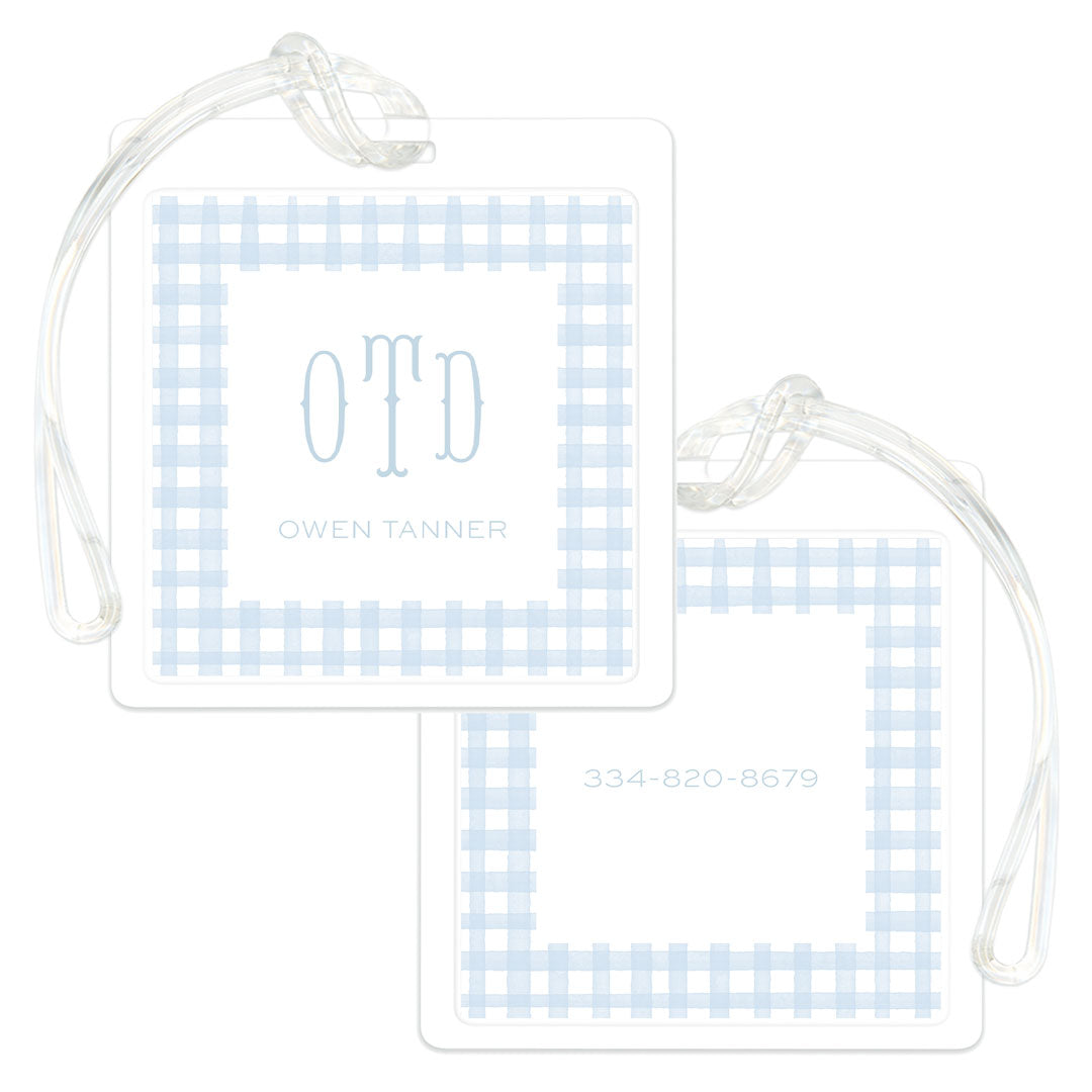 Square luggage tag with a light blue gingham pattern border, personalized with initials and name on one side and a phone number on the other.