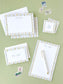 Personalized stationery set with floral striped borders, envelopes, and vintage postage stamps on green background