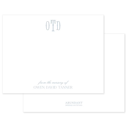 Elegant white stationery card featuring a soft blue monogram and personalized nursery text with classic, timeless design elements.