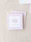 Pink gingham patterned calling cards with elegant monogram initials and personalized name text on a textured neutral background