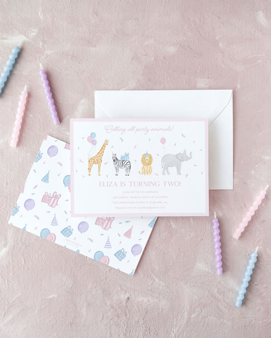 Pink birthday invitation with illustrated safari animals and festive party-themed envelope on a soft pink background.