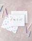 Pink birthday invitation with illustrated safari animals and festive party-themed envelope on a soft pink background.