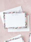 Elegant flat notecard with soft watercolor floral border and personalized calligraphy on textured pink background