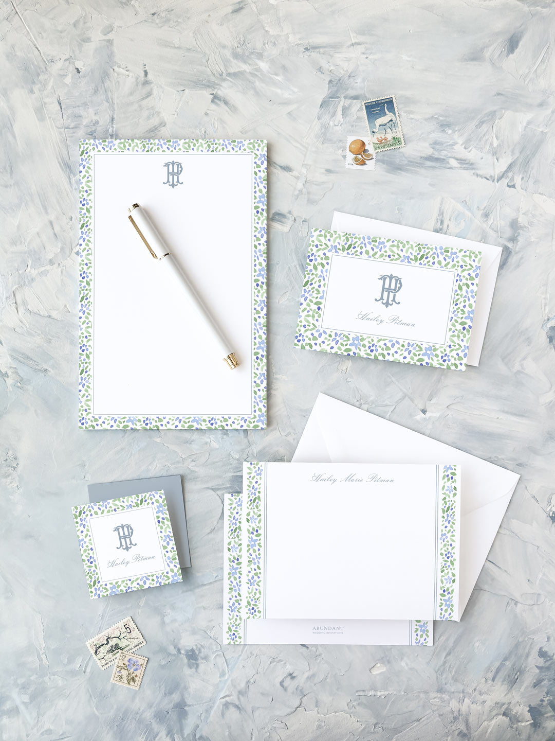 Elegant watercolor floral stationery set with personalized monogram and matching envelopes on textured surface