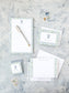 Elegant watercolor floral stationery set with personalized monogram and matching envelopes on textured surface
